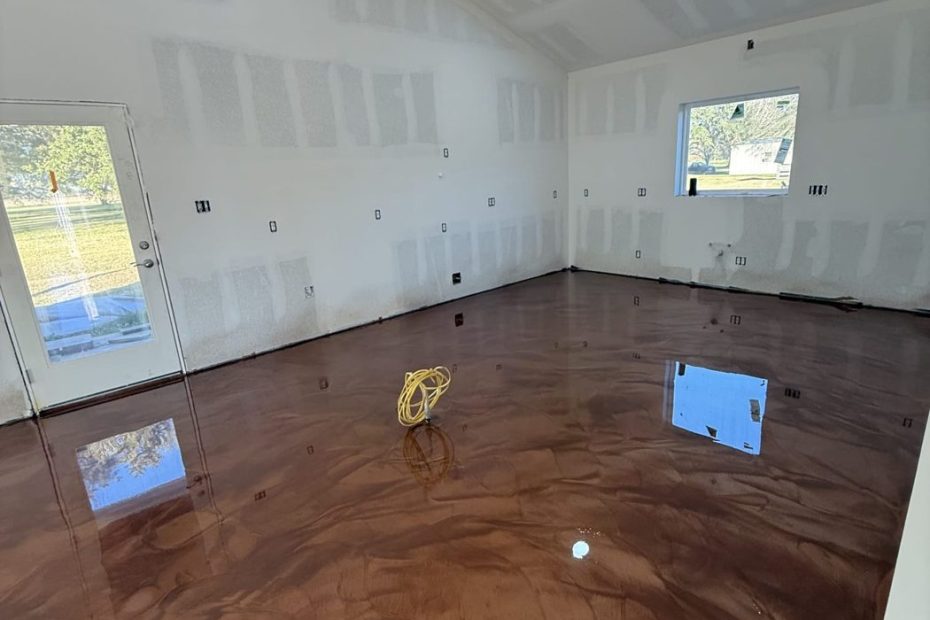 Brown metallic epoxy floor in a garage with white walls and a window